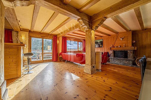 A living room with a red couch and a fireplace with the letter d on the ceiling