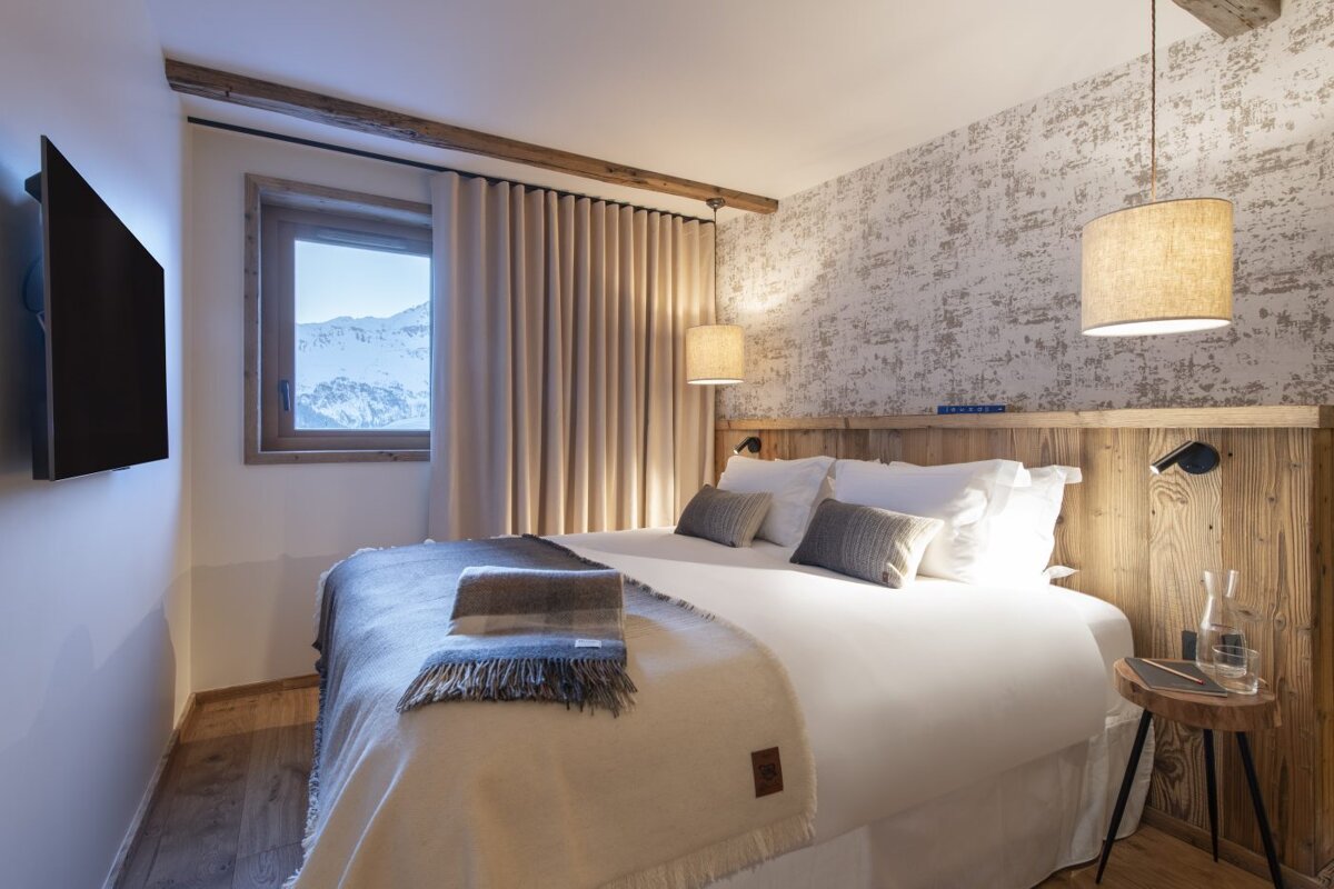 A bedroom with a large bed and a flat screen tv