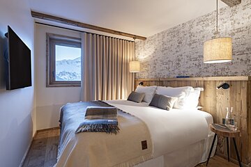 A bedroom with a large bed and a flat screen tv