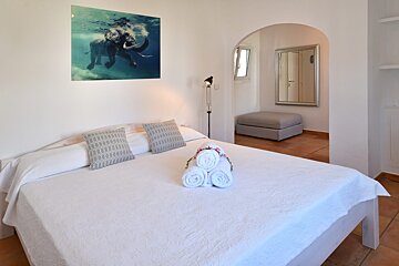 A bed with a picture of an elephant on the wall above it