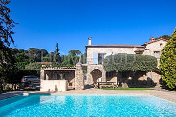 A large stone house with a swimming pool in front of it