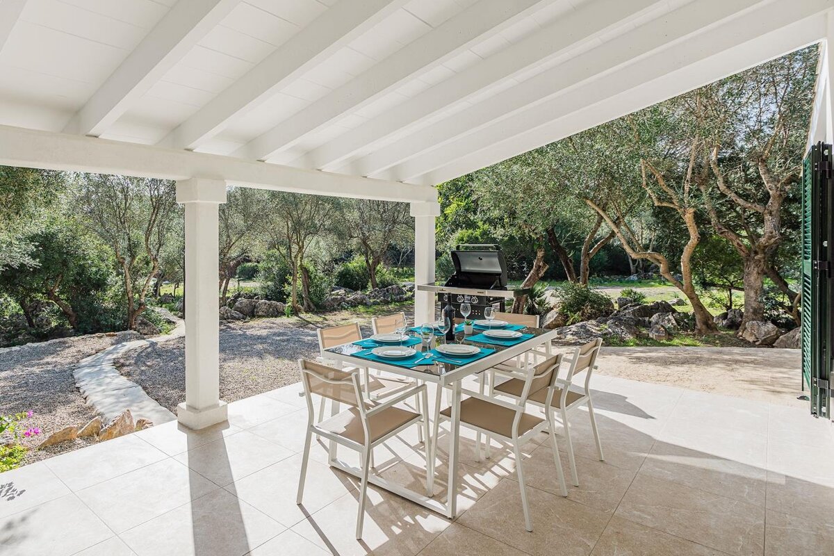 A patio with a table and chairs and a grill