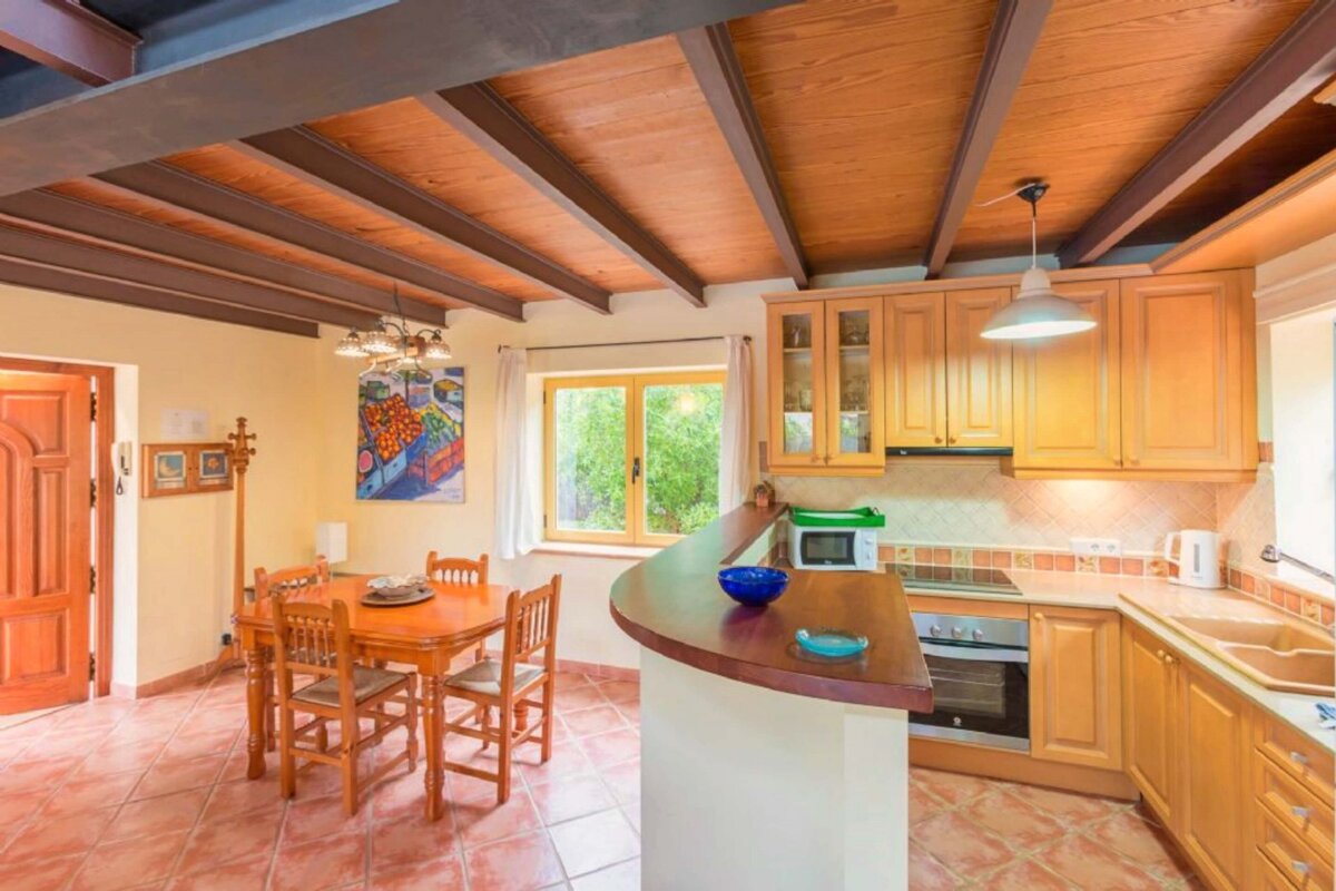 A kitchen with a table and chairs and a painting on the wall
