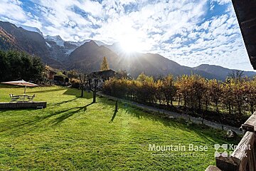 A mountain base real estate advertisement with a view of the mountains