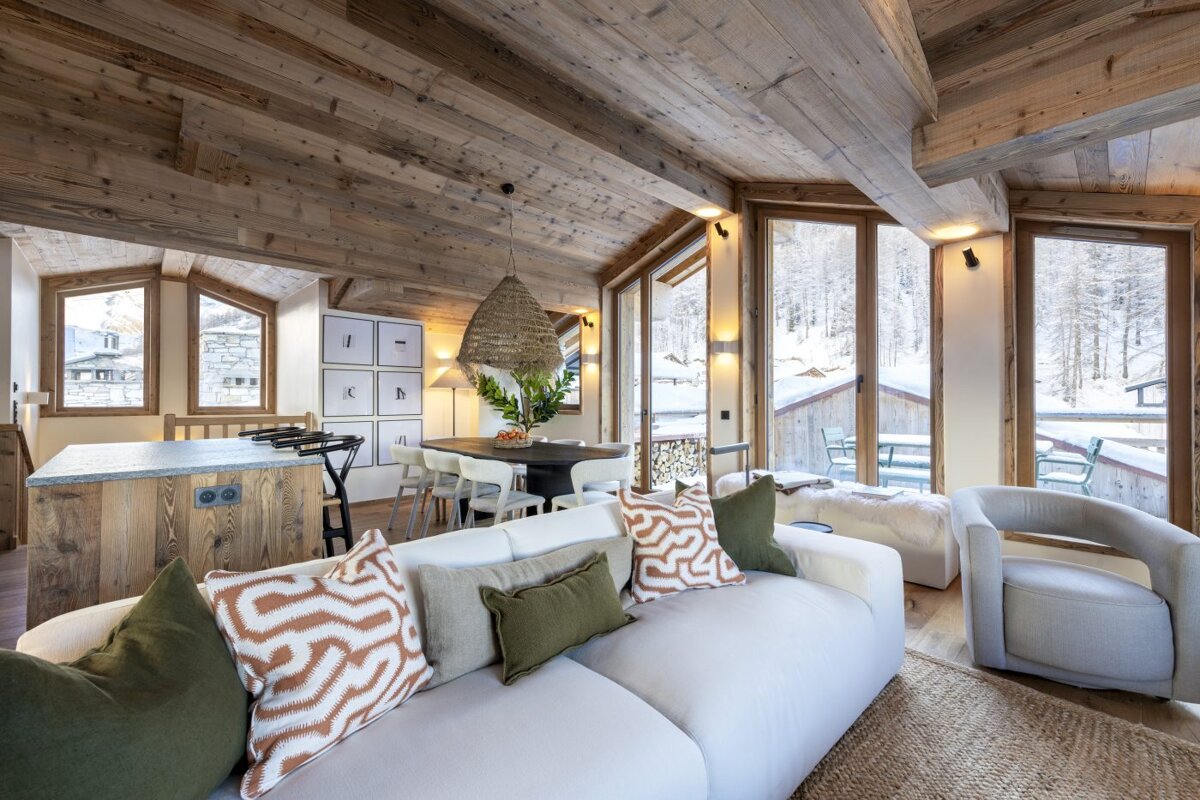 A living room with a white couch and a chair