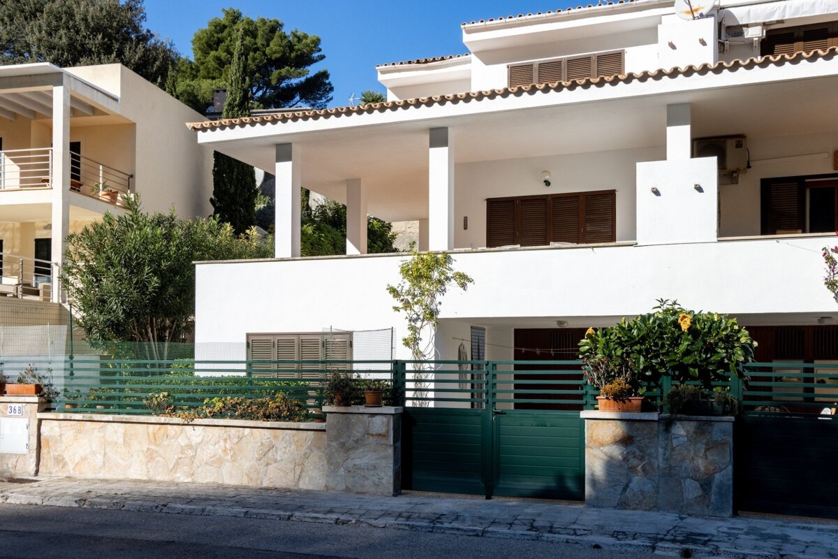 A white house with a green fence in front of it