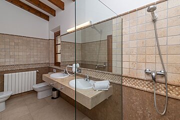 A bathroom with two sinks and a walk in shower