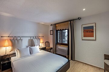 A bedroom with a bed and a picture on the wall