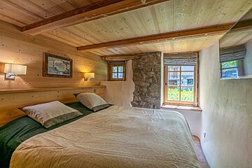 A bedroom with a bed and a picture on the wall