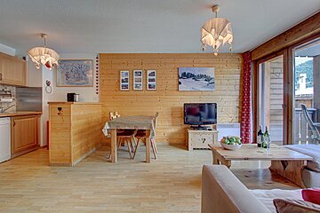 A living room with a table and chairs and a television