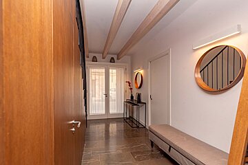 A hallway with a bench and a mirror on the wall
