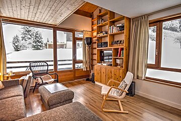 A living room with a couch a chair and a bookshelf