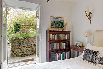 A bedroom with a bookcase that has a book titled