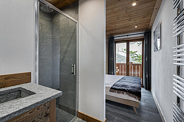 A bedroom with a large bed and a balcony