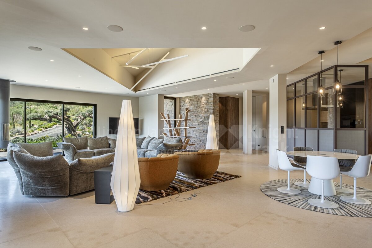 A living room with a table and chairs and a sign that says ' immobilier ' on it