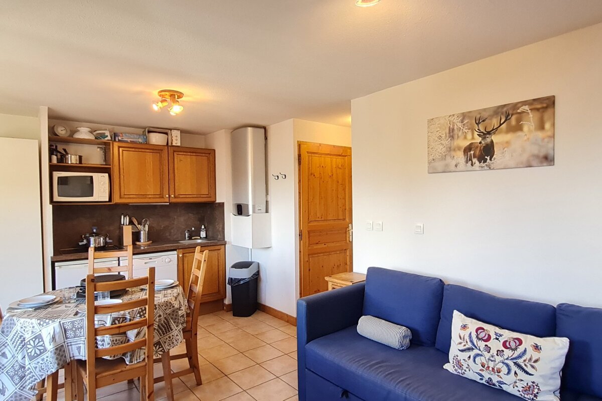 A living room with a blue couch and a picture of a deer on the wall