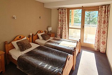 A bedroom with two twin beds and a sliding glass door