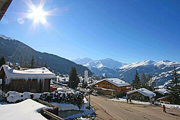 A snowy landscape with mountains in the background