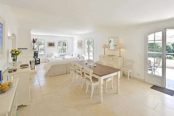A white living room with a wooden table and chairs