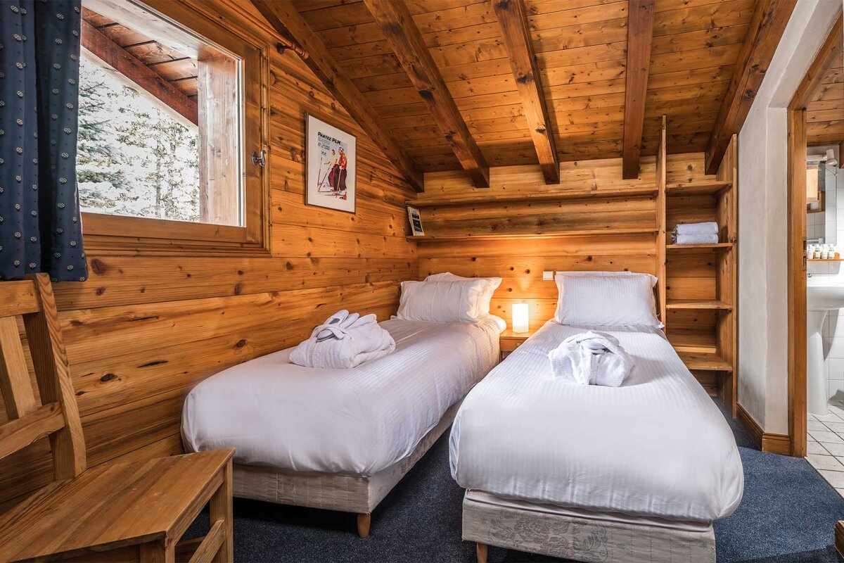 A bedroom with two twin beds and a picture of a man skiing on the wall