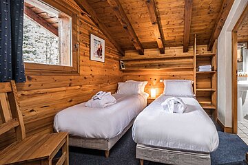 A bedroom with two twin beds and a picture of a man skiing on the wall