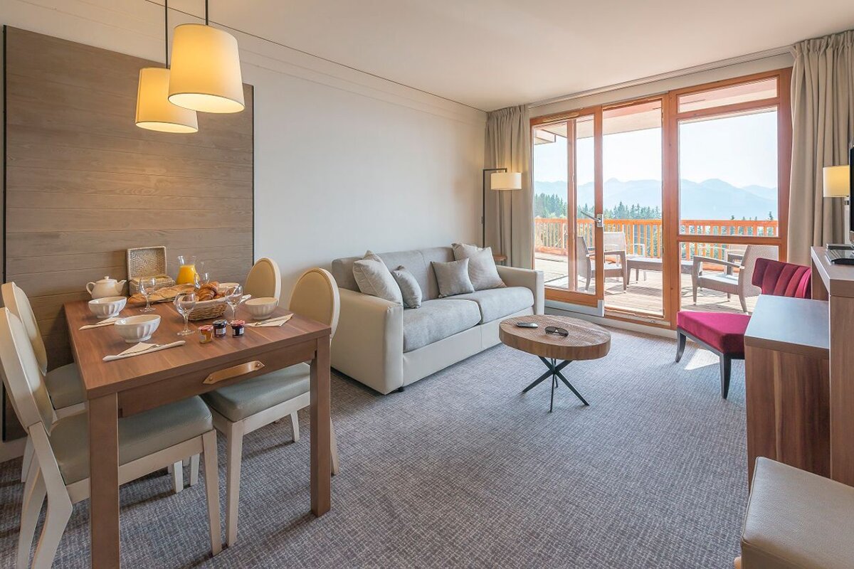 A living room with a couch a table and chairs