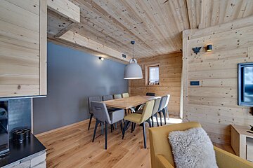 A dining room with a wooden table and chairs