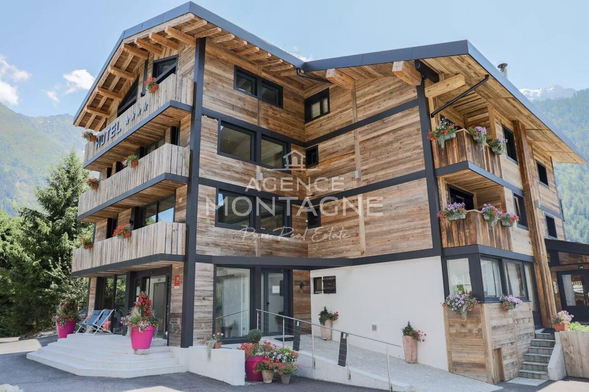 A multi-story wooden hotel with flower-filled balconies, nestled in the mountains. 