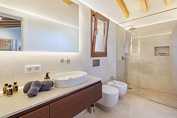 A bathroom with a sink toilet and bidet