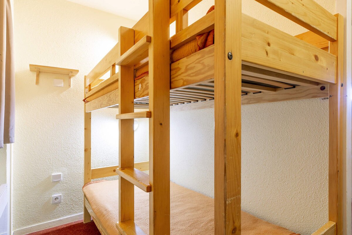 A bunk bed in a room with a green door