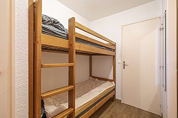 A bunk bed in a small room with a door