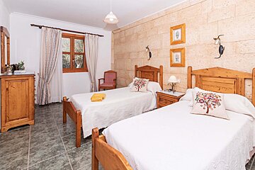 A bedroom with two twin beds and a dresser