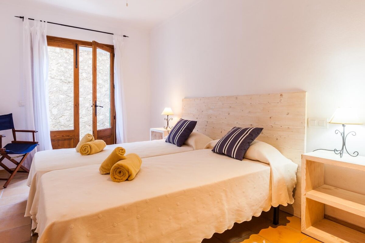A bedroom with two beds and a wooden headboard