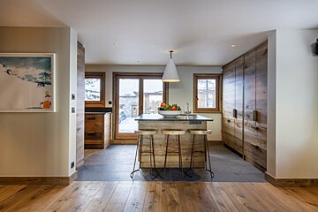 A kitchen with wooden cabinets and a bowl of fruit on the counter