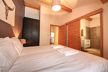 A bedroom with a sliding door that leads to a bathroom