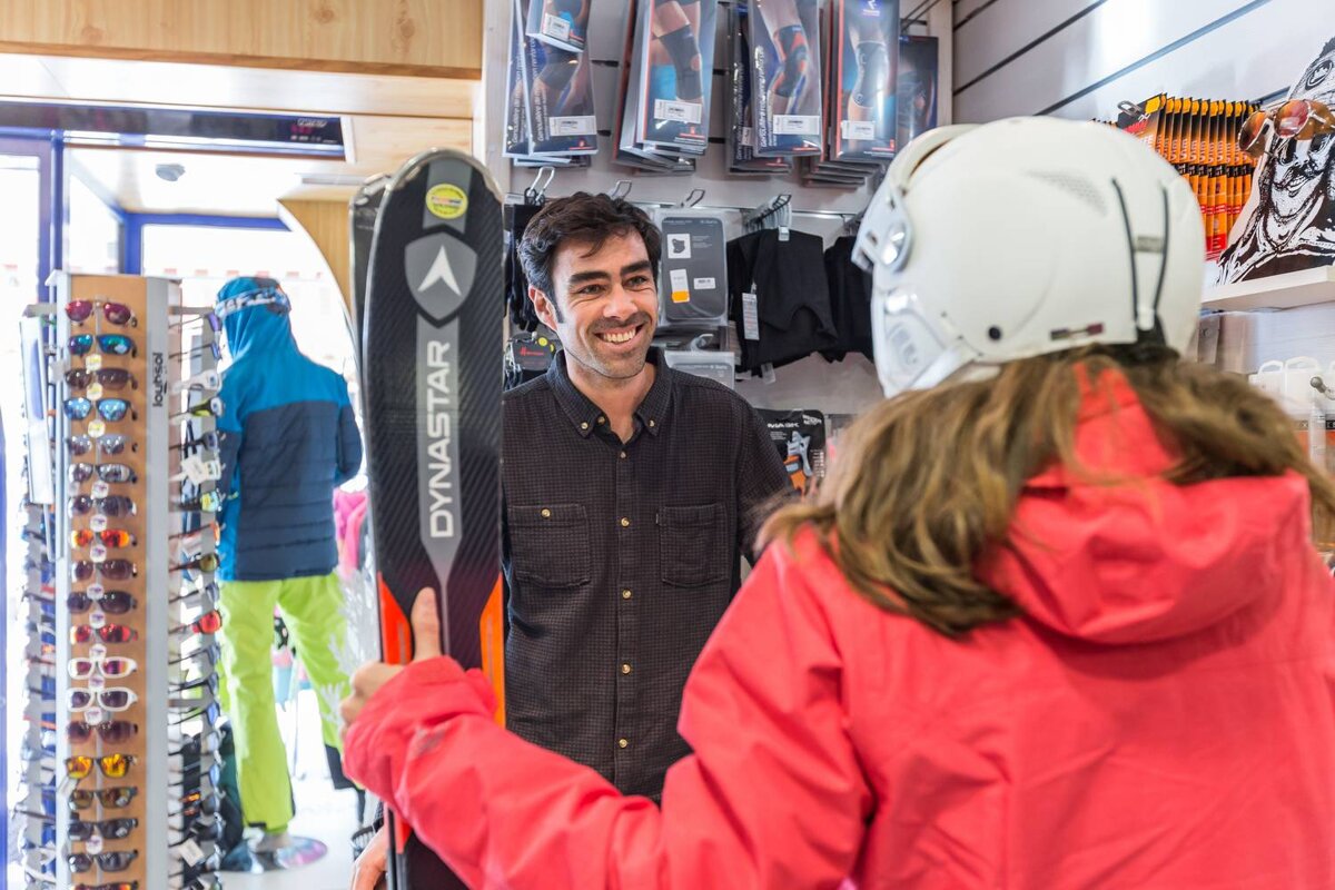 A man holding a dynastar skis in a store