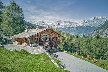 A large house with mountains in the background is for sale