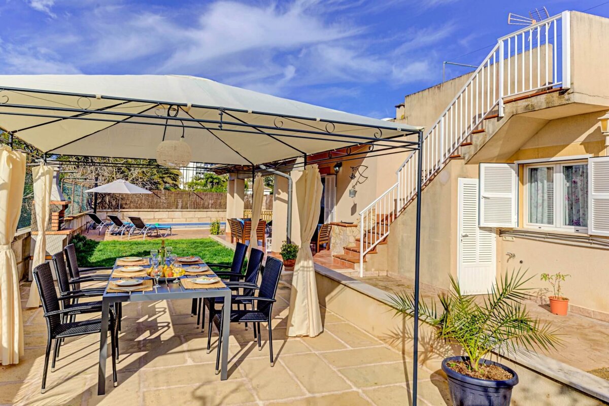 A patio with a table and chairs under a canopy