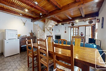 A dining room with a wooden table and chairs and the word alpine on the bottom