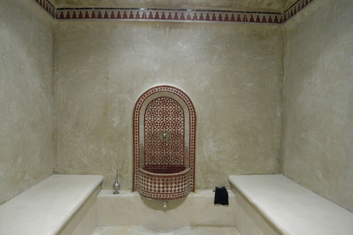 A bathroom with a red and white fountain in the middle