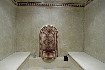 A bathroom with a red and white fountain in the middle