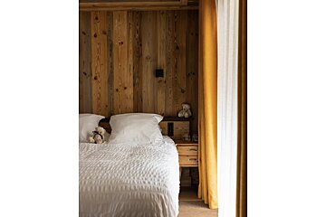 A bedroom with a teddy bear on the bed