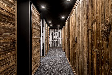 A hallway with wooden doors and a black ceiling