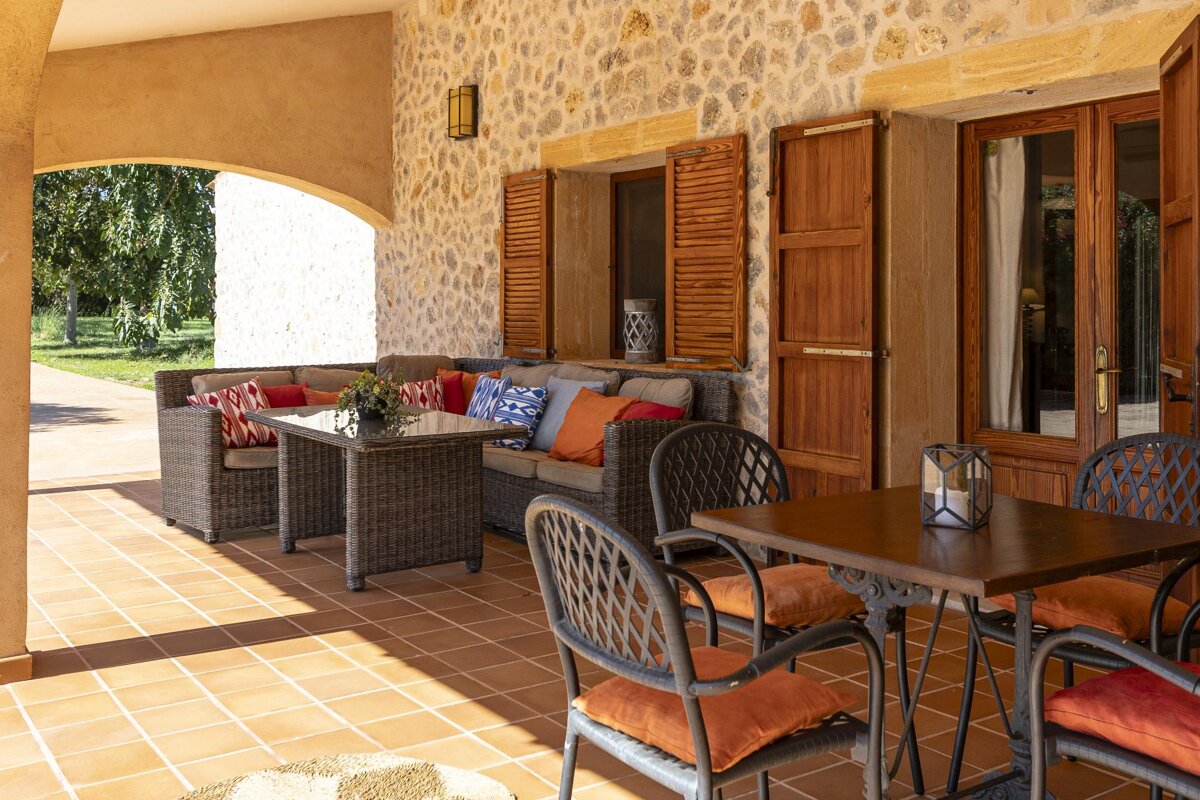 A patio with wicker furniture and a table
