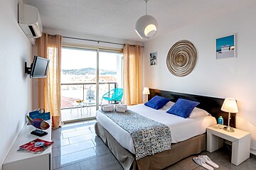 A hotel room with a large bed and a television