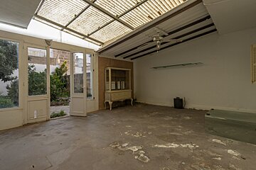 An empty room with a cabinet and a ceiling fan