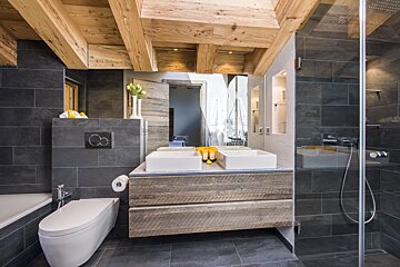 A bathroom with two sinks and a toilet