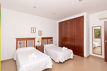 A bedroom with two twin beds and a mirror