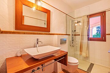 A bathroom with a sink a toilet and a mirror