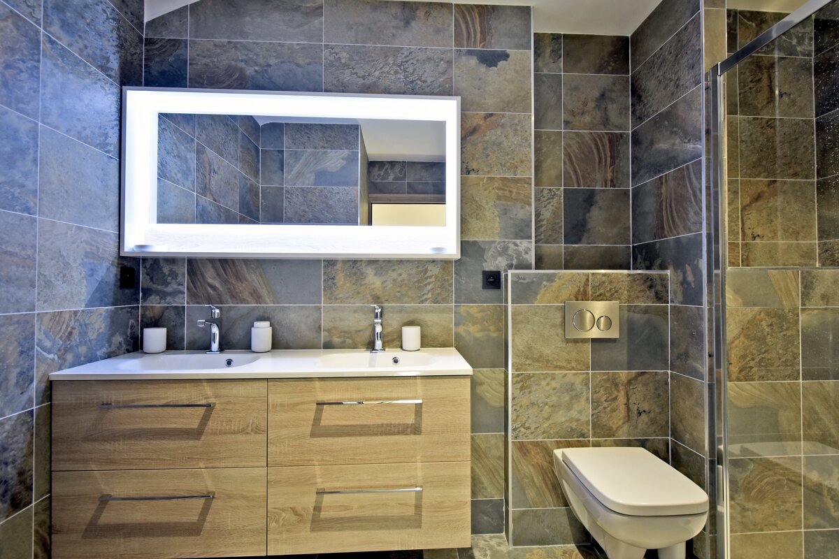 A bathroom with a toilet a sink and a mirror